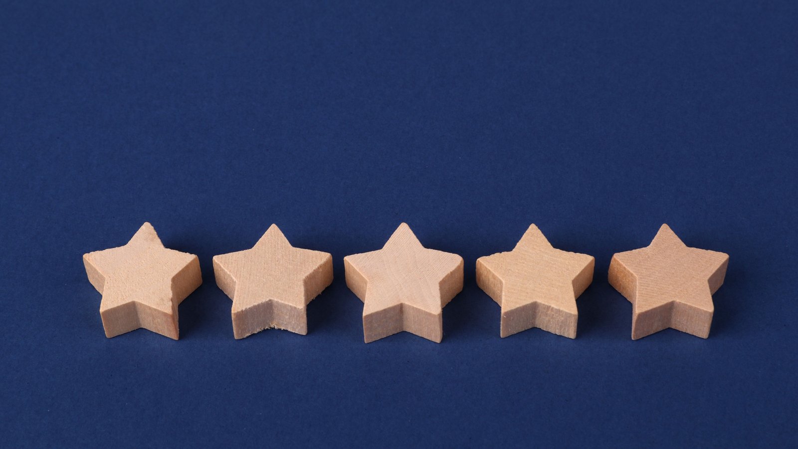 Five wooden stars in a row, representing Berkat Madinah Store's reported 5-star customer rating